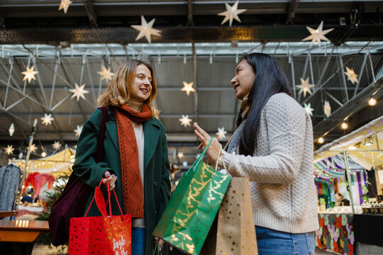 Friends enjoying christmas shopping at winter market
