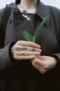 Girl holding a flower in her hands while outdoors in nature