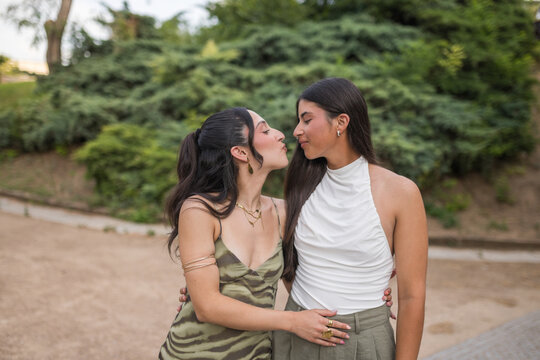 Smiling Young Women Looking at Each Other Intimately Outdoors