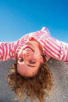 Smiling woman leaning backward over granite slab