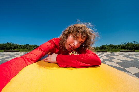 Woman in red lying on yellow bench