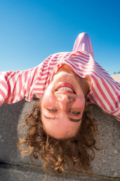 Smiling woman leaning backward over granite slab