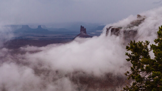 Candlestick Tower with Rolling Fog from Dead Horse Point. Bands of low cloud sweep across the canyon surrounding Candlestick Tower during changing weather at Dead Horse Point State Park.