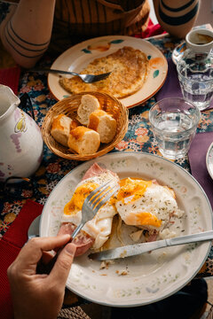 People Enjoy Breakfast With Eggs and Bread at a Table
