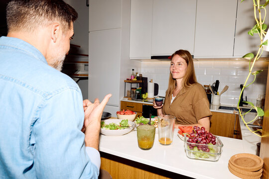 Two people enjoy lunch together in a modern kitchen