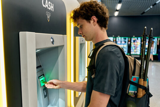 Young Man Using ATM in a Modern Indoor Space