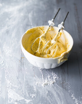 Mixing raw cake dough in a bowl with an electric mixer