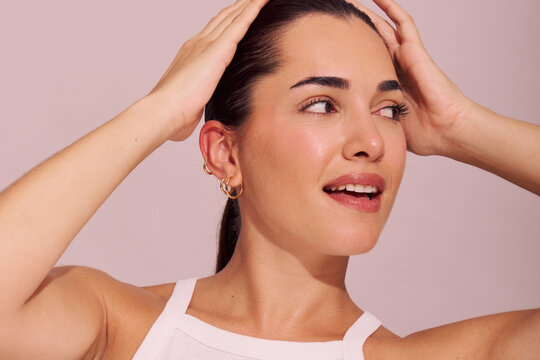 Woman Touches Her Hair With a Smile in a Bright Setting