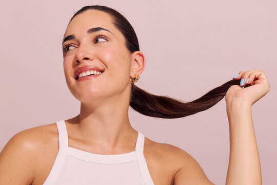 Woman Shows Long Hair While Smiling in Studio Setting