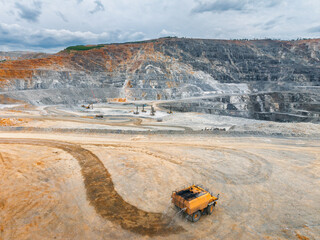 Obraz na płótnie Canvas Wide open pit mine with haul truck traversing dirt road