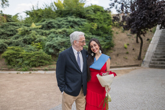 Proud Grandfather Standing with Graduated Granddaughter