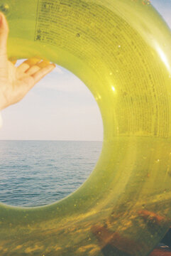 person holds a green float by the edge of the water