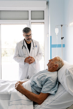 Doctor discussing with senior patient in hospital room