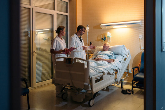 Medical team talking with senior patient in hospital bed