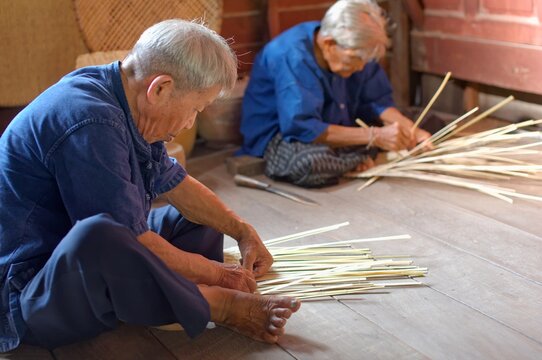 Elderly Artisans Weave Bamboo Fan Together in Rural Thai Home