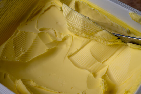 Close Up of Butter Spread in Container With Knife