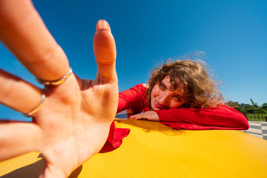 Woman reaching toward camera outdoors