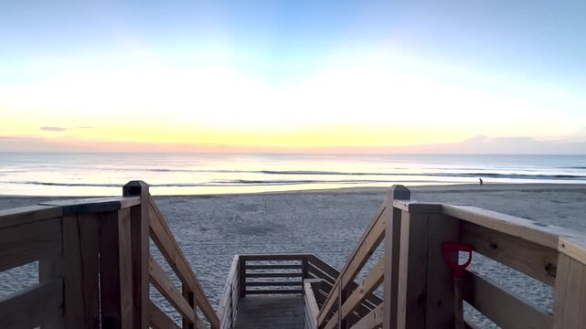 Looking out at the water at Sunrise in Corolla North Carolina with a runner jogging along the shore in the background.