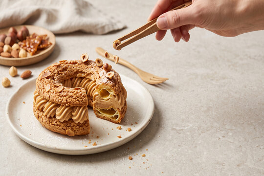 Paris Brest pastry with hazelnut cream and nuts during preparation with selective focus