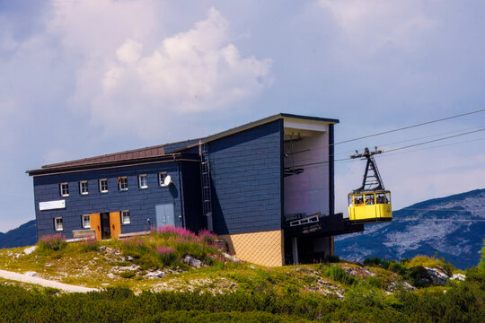 Dachstein Krippenstein, iconic bright yellow cable car cabins and gondolas that transport visitors up the mountain slopes in Obertraun, Austria.
