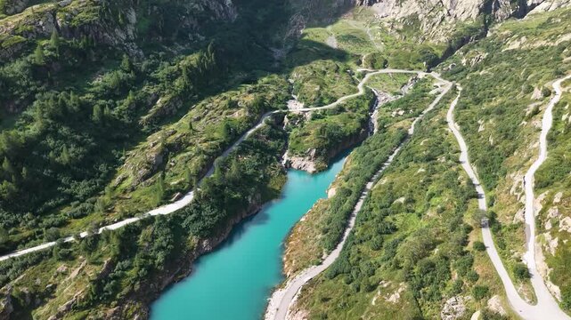Routes en lacets et retenue turquoise sous le barrage d'Emosson