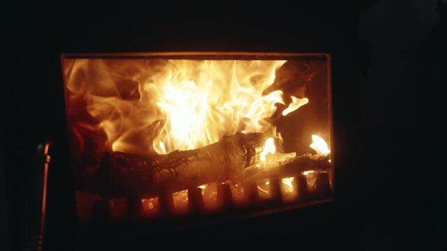 Close-up of Burning Firewood and Flickering Flames in a Fireplace