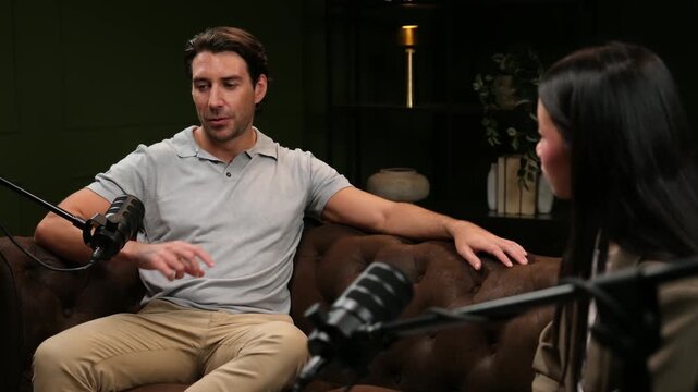 Male influencer guest talking to female host during a live podcast interview in a modern studio