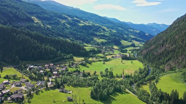 Aerial view of mountain village in green valley in sunny day