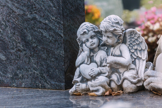 Kleine Erinnerungen am Grab auf dem Parkwald Friedhof im August mit zwei kleinen Engelsfiguren