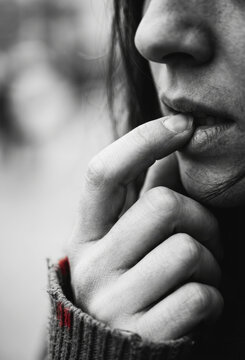 Close up of a person biting their fingernail in anxiety