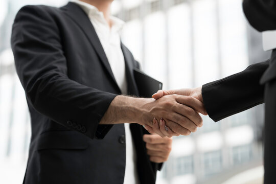 Business partner handshake for business deal with office business building blur background. Businessman shake hand with partner and make deal, appointment investment together