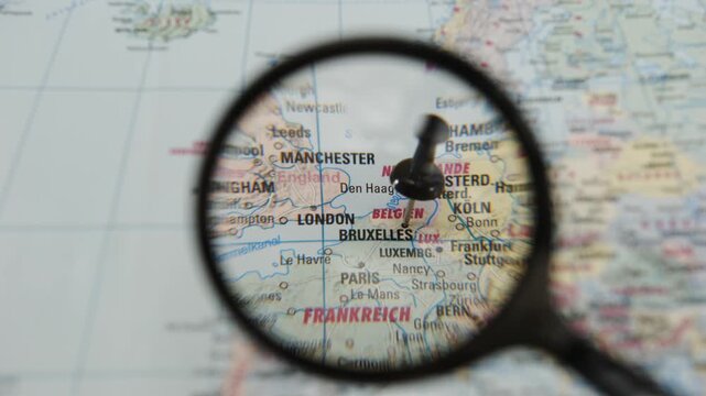 Magnifying glass reveals Brussels on a printed paper map