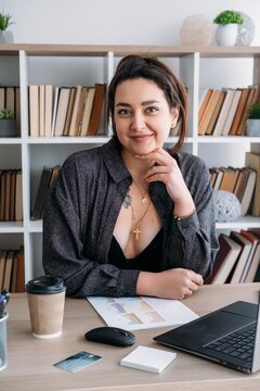 Office career. Manager paperwork. Smiling business woman professional specialist at desk with credit card document using laptop indoor.