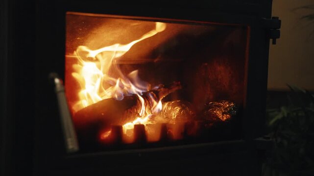 Slow Motion Close-up of Burning Firewood and Flickering Flames Inside