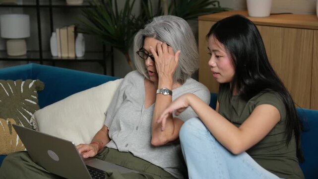 Multiethnic family members bonding together while browsing the internet on a computer at home