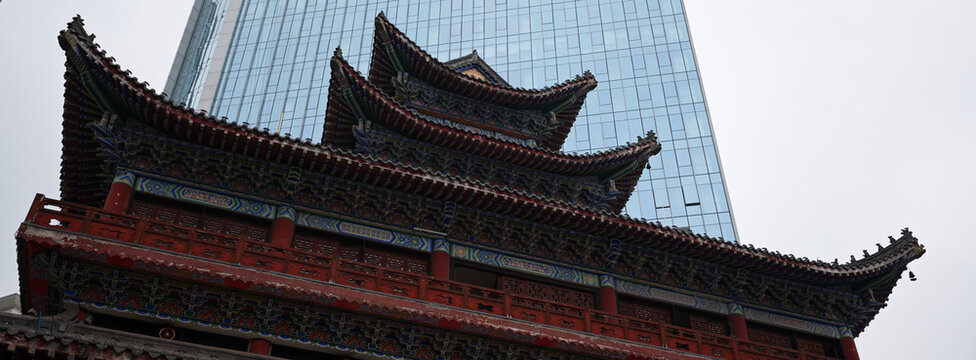 Golden tiered temple roofs against glass skyscrapers, China