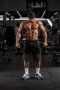 Muscular man in gym showing muscles. Strong male naked torso abs