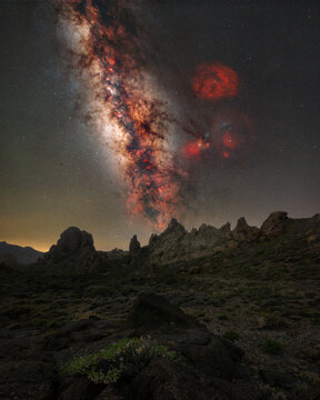 View of the iconic Roque Cinchado rock formation under a vibrant Milky Way galaxy in the night sky of Teide National Park, Santa Cruz de Tenerife, Canary Islands, Spain.