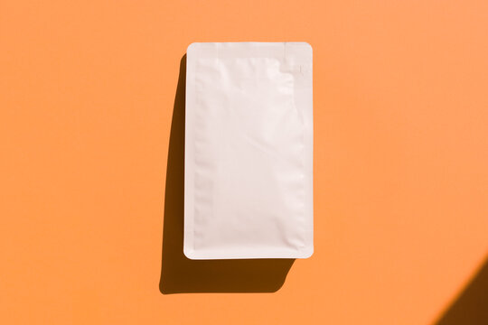 Blank craft plastic pouch, white pack on studio background with shadow, mylar bag isolated for coffee or food, cosmetic products, snack, candy. Different sizes, mock up.