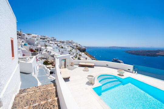 White architecture in Santorini island, Greece. Blue sea and the blue sky at sunny day. Luxury swimming pool with blue water.