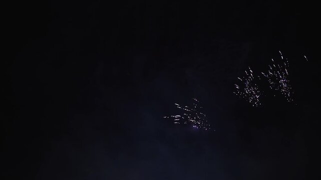 Buntes Silvesterfeuerwerk mit Raketen am Nachthimmel