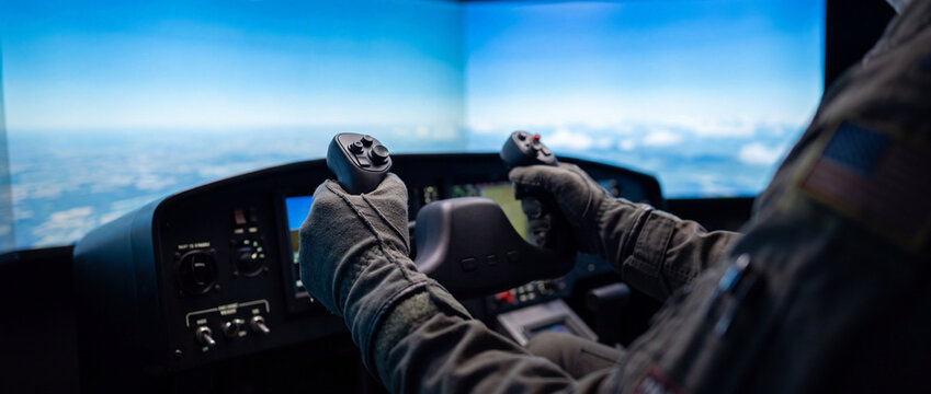 Pilot hands on yoke in cockpit controls during flight simulator training over cloudy horizon