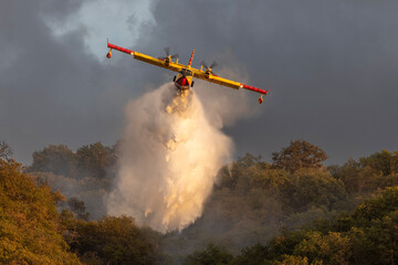 A dramatic scene of a Canadair CL-415 water bomber releasing its load over a burning forest in Zambrone, Calabria, Italy, September. Captured as firefighters fought to contain the spreading wildfire. © Adam