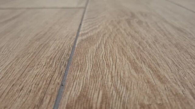 Close-up shot of a textured light brown laminate flooring pattern at home. interior design renovation, modern floor covering, home decor background.