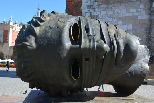 KRAKOW POLAND: Eros Bendato (Eros bound) giant head statue in Rynek Glowny, Krakow. The bronze noggin was sculpted by Igor Mitoraj in 1999 and moved to Krakow in 2003.