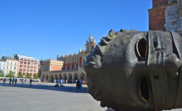 KRAKOW POLAND: Eros Bendato (Eros bound) giant head statue in Rynek Glowny, Krakow. The bronze noggin was sculpted by Igor Mitoraj in 1999 and moved to Krakow in 2003.