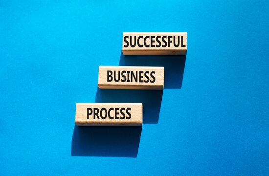 Successful business process symbol. Concept words successful business process on wooden blocks arranged as steps. Business development concept. Blue background. Copy space.