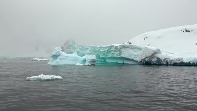 Gigantic frozen structures float calmly across the dark chilling waves of Antarctica.