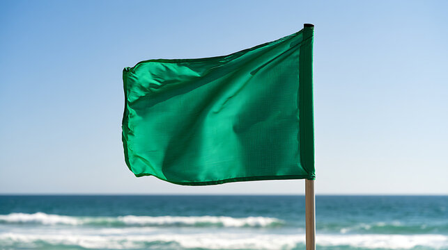 Drapeau vert au bord de la mer avec des vagues et un ciel bleu pendant la journ&eacute;e