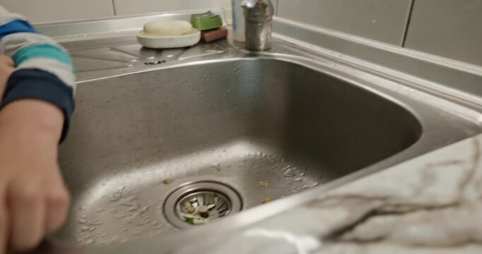 Kid hands wash sink. Boy helping in kitchen. 4K 10-bit